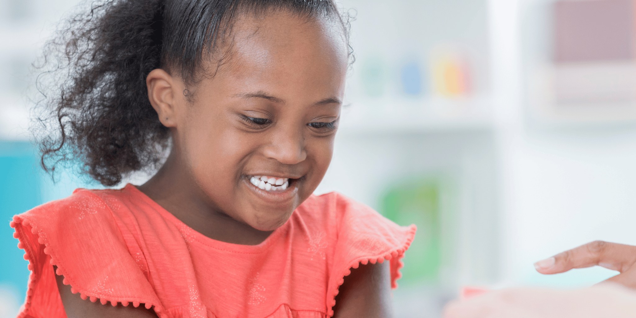 A smiling girl in an orange top