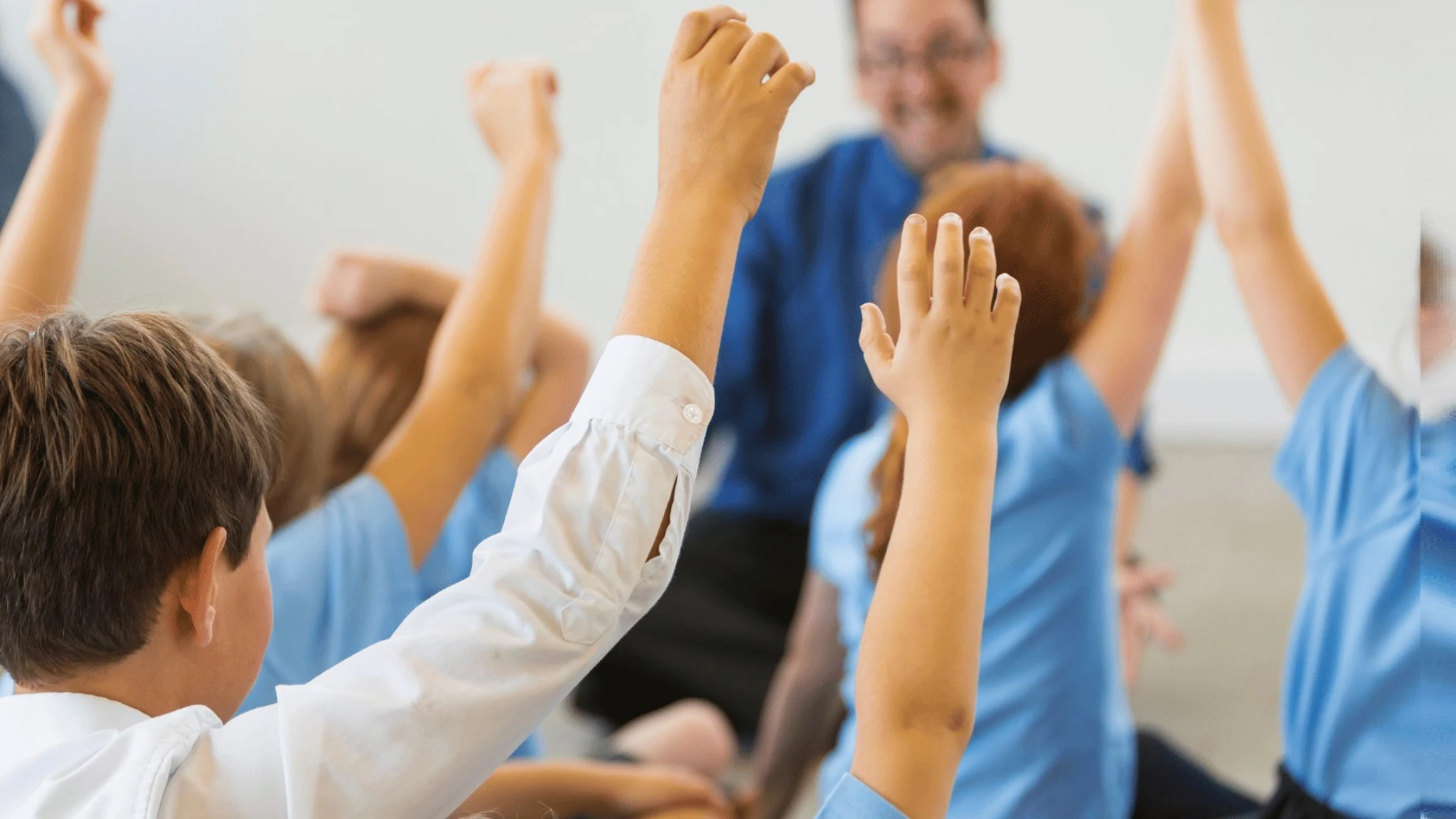 Children raising their hands in a classroom