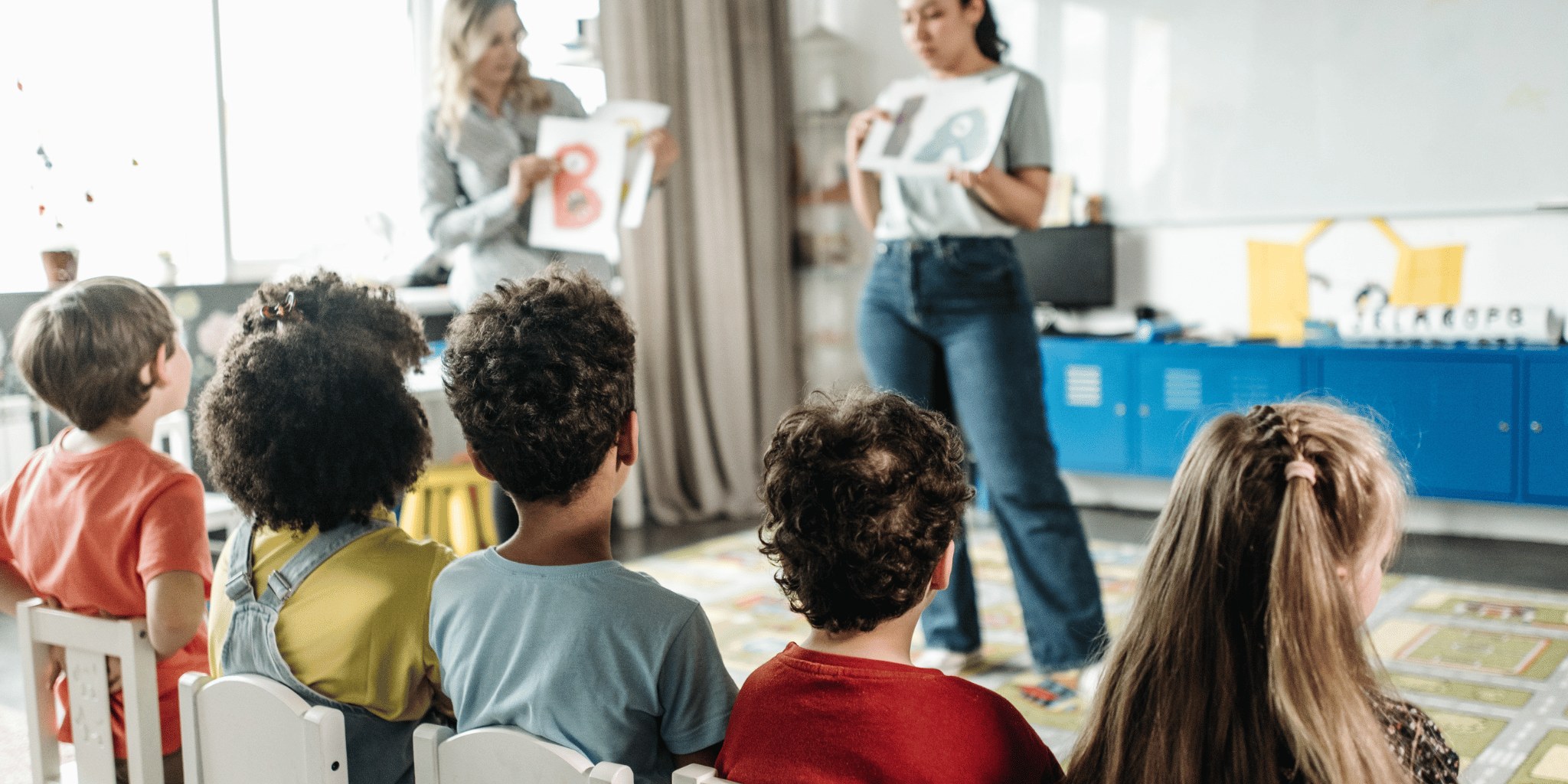 A woman working with a group of children in a classroom