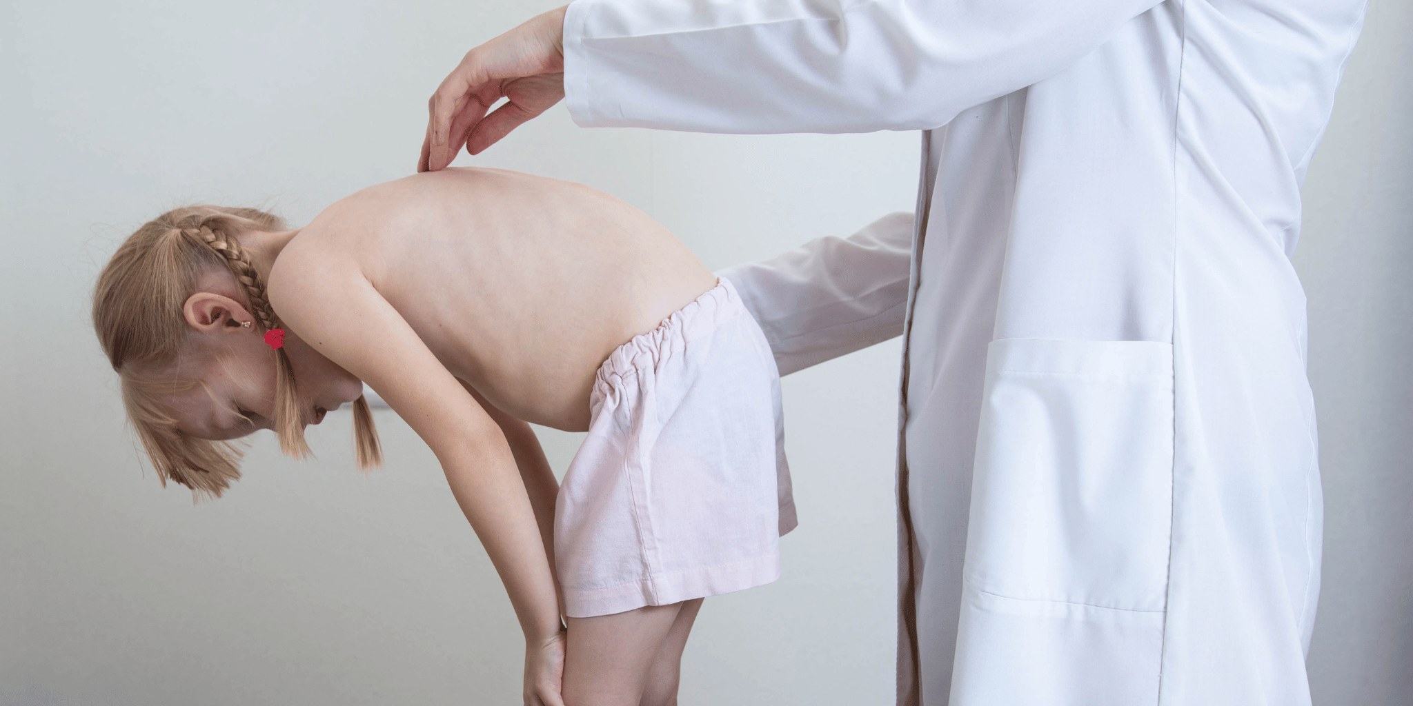 A doctor examining a young child's back