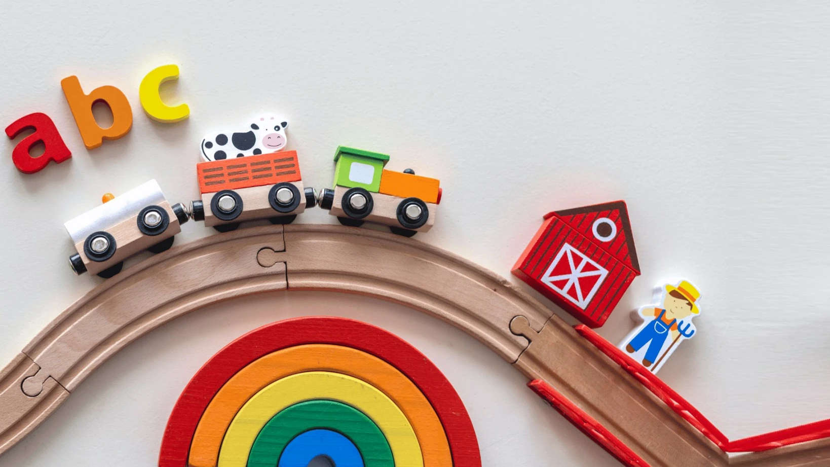 Alphabet blocks beside a wooden rainbow toy