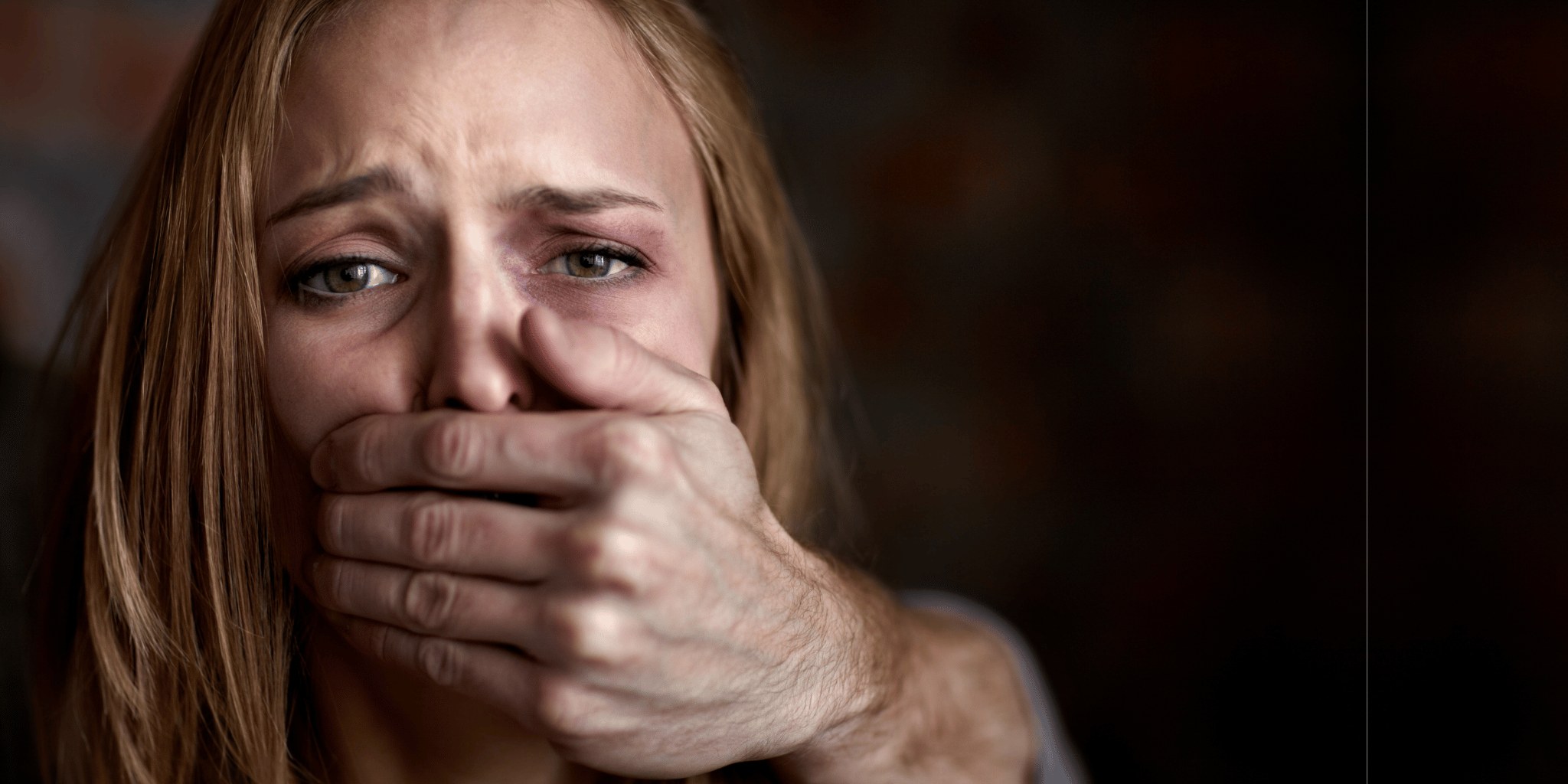 A woman with a hand held over her mouth